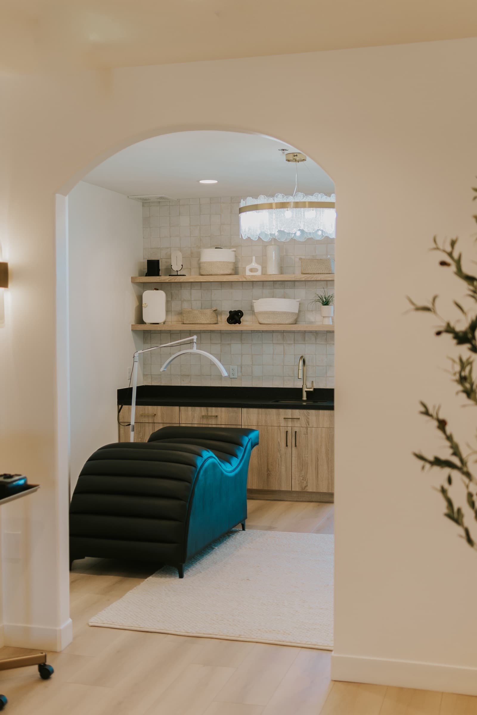 An arched doorway opening into a private suite with its own wash station and shelving.