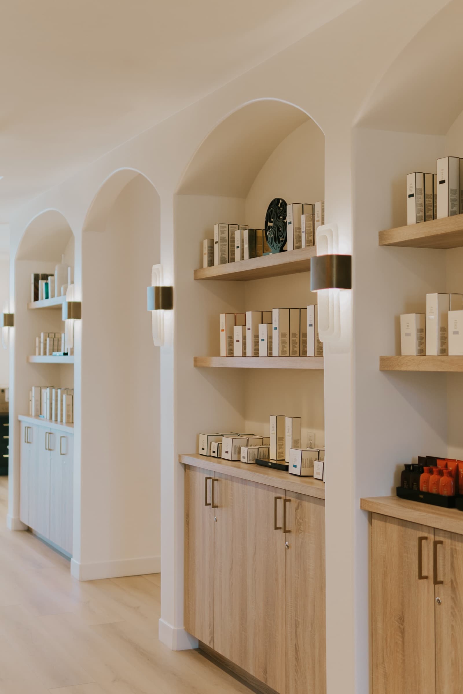 The arched retail alcoves at the front of the salon, lined with haircare.